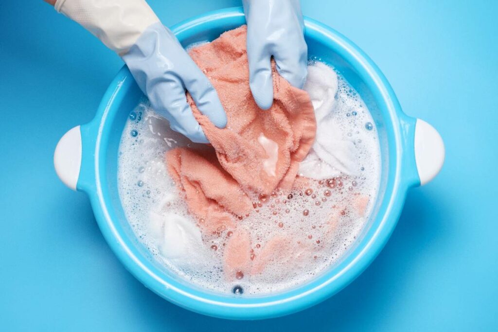 female-hands-in-rubber-gloves-washing-pink-clothes-2023-11-27-05-20-01-utc