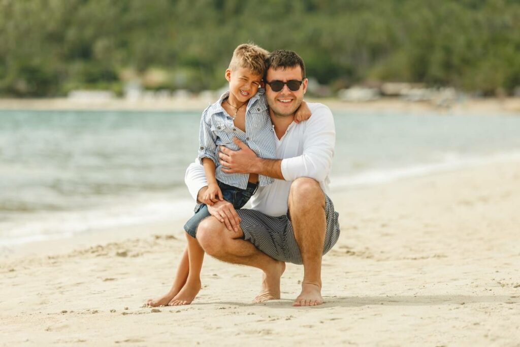 happy-handsome-father-and-son-embracing-on-tropica-2023-11-27-05-11-21-utc