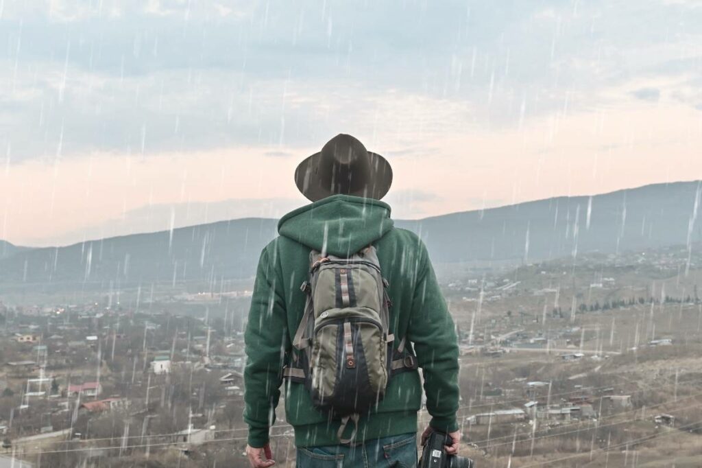 man-looking-at-the-mountains-in-the-rain-2023-11-27-04-53-23-utc