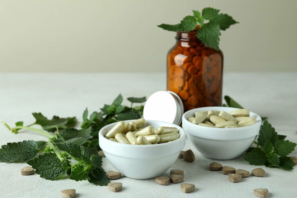 nettle-pills-and-ingredients-on-white-textured-tab-2023-11-27-05-04-44-utc